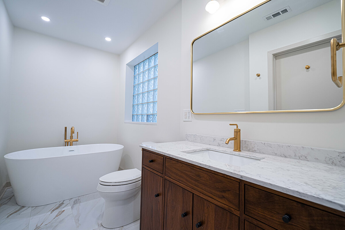 Bathroom Remodel with tub, toilet, sink, and mirror